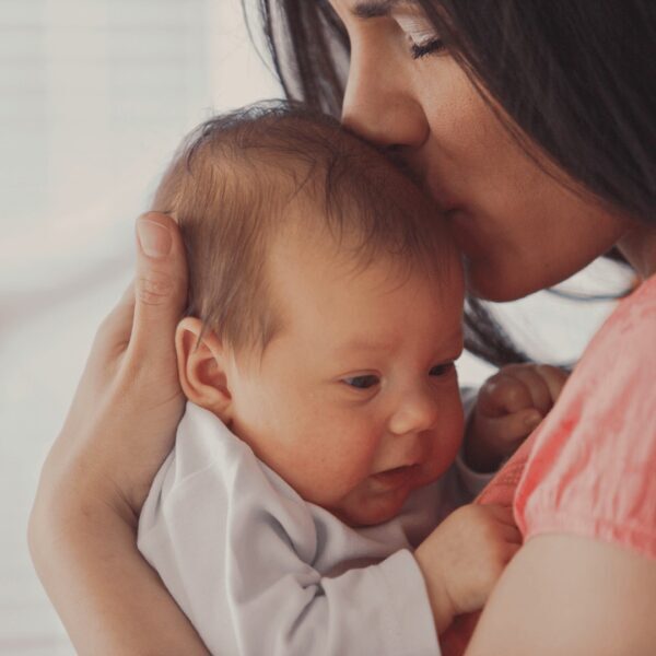 Mother kissing newborn during postnatal relaxation